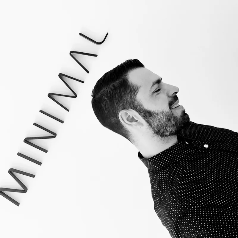 Andrés Palacios, director de arte de Minimal, junto al rótulo del estudio